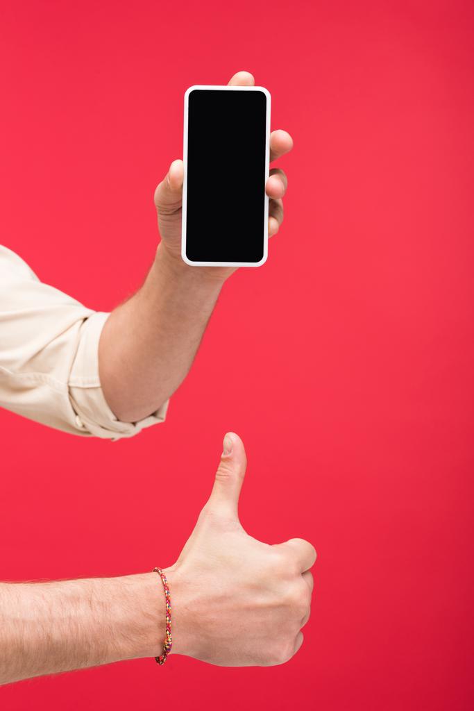Levágott kilátás-ból ember tárolás Smartphone-val üres képernyő és csinálás hüvelykujj megjelöl jel elszigetelt-ra rózsaszín - Fotó, kép