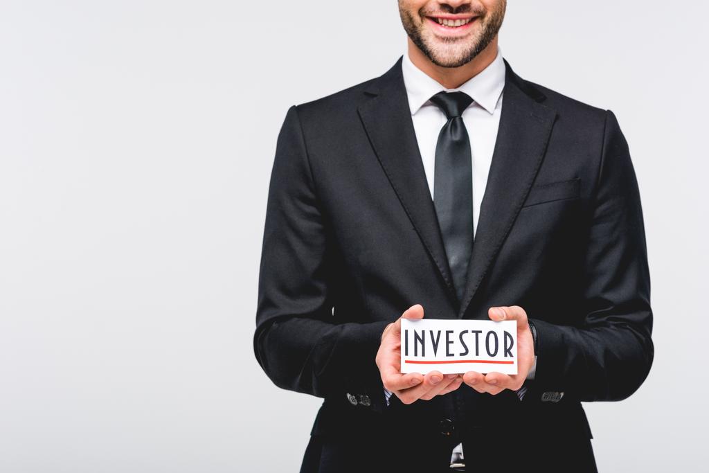 recortado vista de hombre de negocios en traje hodding tarjeta con palabra de inversor aislado en gris
 - Foto, imagen