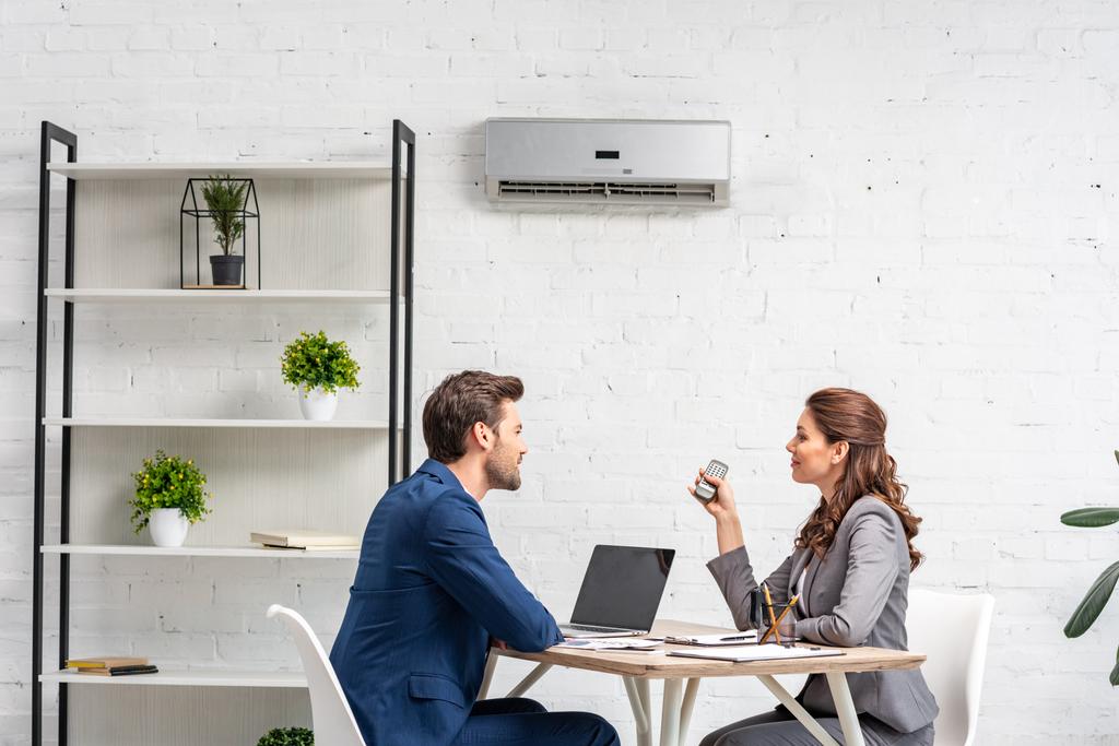 partenaires d'affaires parler tout en étant assis sur le lieu de travail sous climatiseur
  - Photo, image