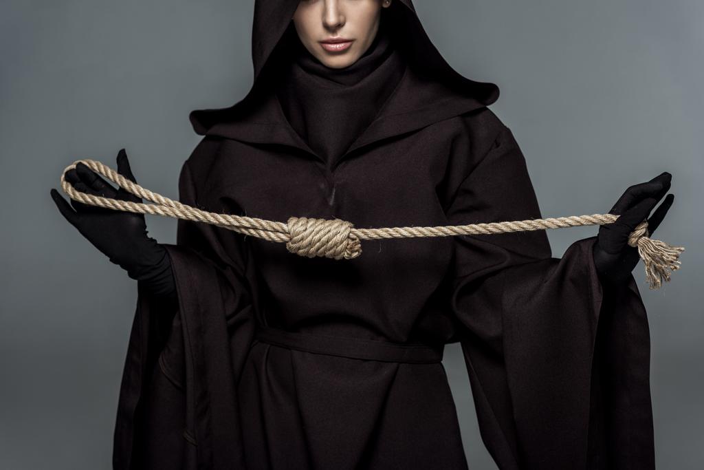 cropped view of woman in death costume holding hanging noose isolated on grey - Photo, Image