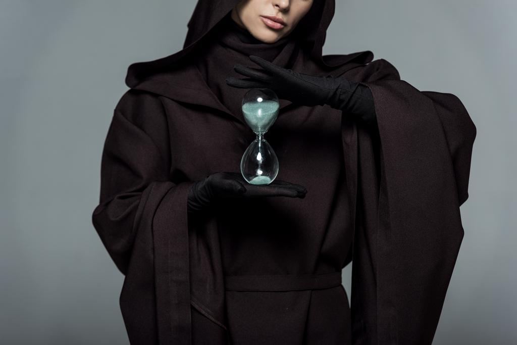 partial view of woman in death costume holding sand clock isolated on grey - Photo, Image