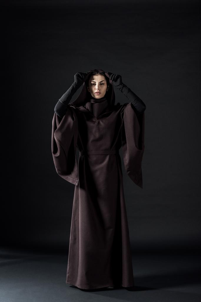 Ganzkörperansicht einer Frau im Todeskostüm auf schwarz - Foto, Bild