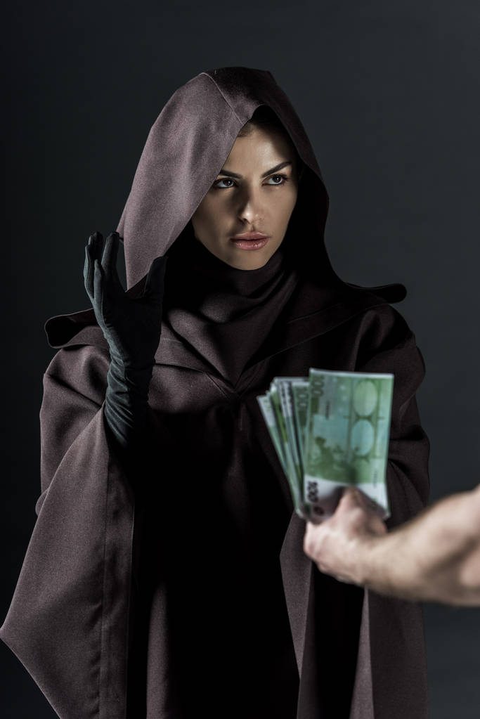 osittainen kuva miehestä, joka antaa euroseteleitä naiselle mustalla eristetyssä puvussa
 - Valokuva, kuva