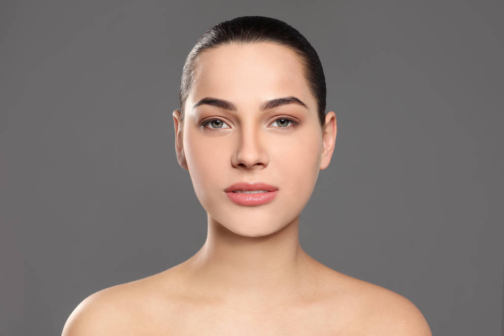 Πορτρέτο της νεαρής γυναίκας με όμορφο πρόσωπο και φυσικό μακιγιάζ στο φόντο χρώμα - Φωτογραφία, εικόνα