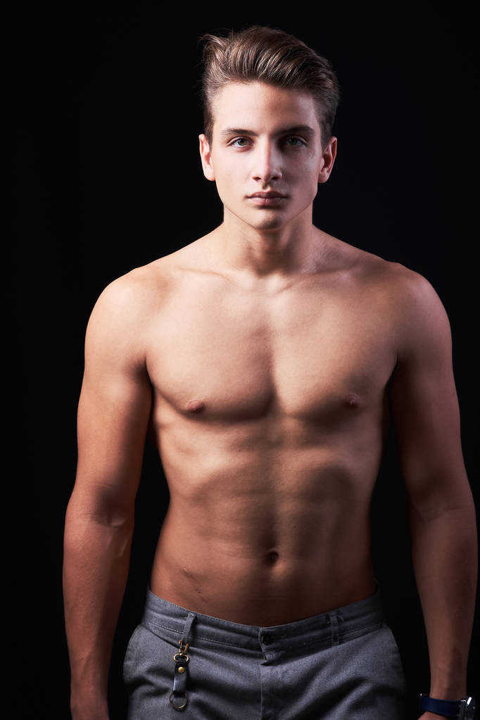 Studio portrait of handsome muscular shirtless young man isolated on black - Photo, Image