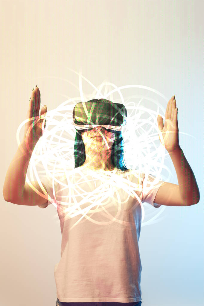 young woman in virtual reality headset holding glowing abstract illustration on beige and blue background - Photo, Image