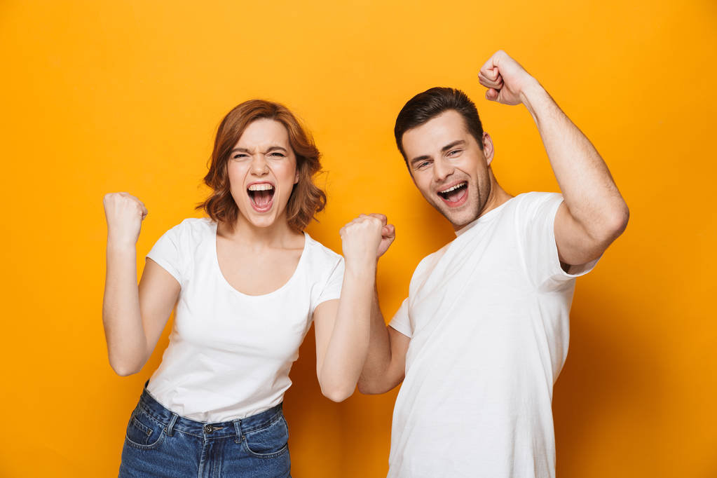 Excited beautiful couple wearing white t-shirts standing - Photo, Image