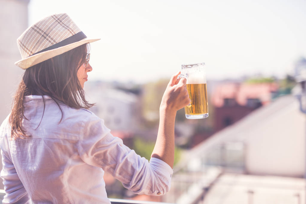 Linda chica bebiendo cerveza en una terraza
. - Foto, imagen