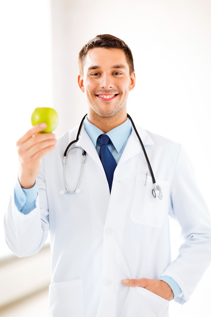 Médico masculino con manzana verde
 - Foto, imagen