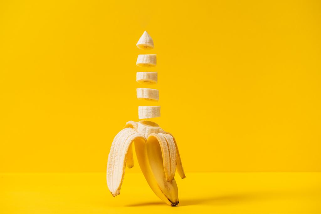 黄色に分離されたスライス熱帯甘いおいしいバナナ - 写真・画像