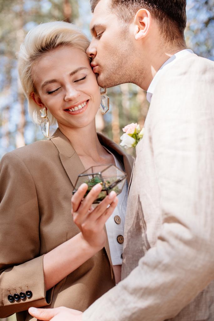 vista cortada do noivo beijando noiva com os olhos fechados
 - Foto, Imagem