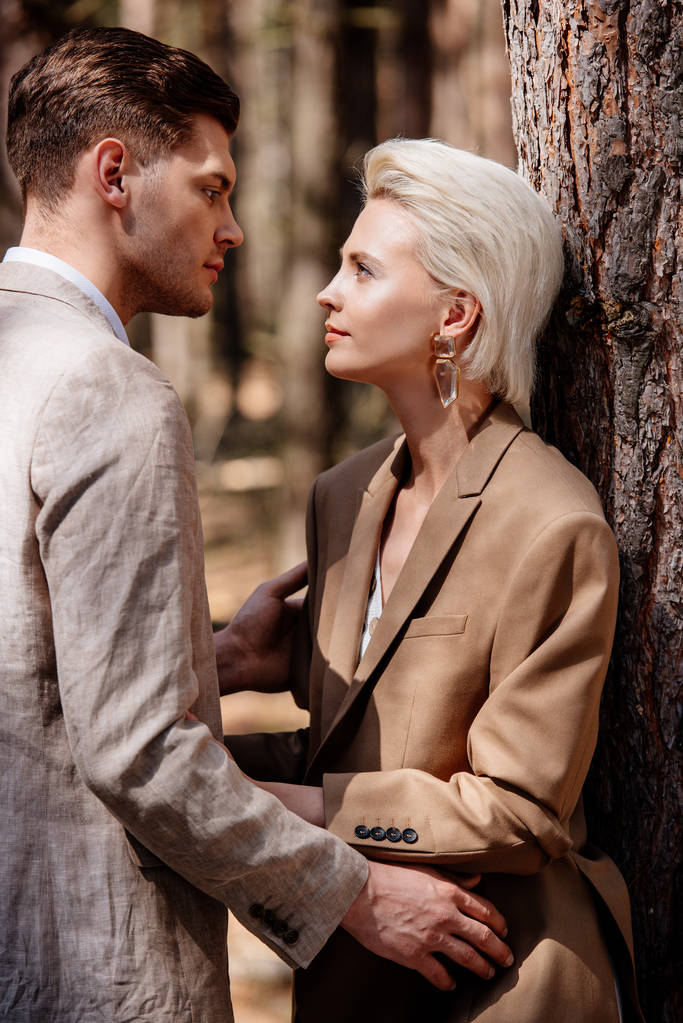 стильна пара в офіційному одязі дивиться один на одного в лісі
 - Фото, зображення