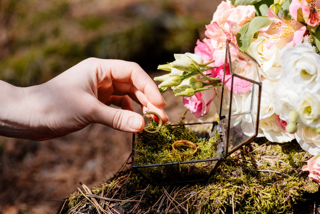 vista cortada da noiva com flores e anéis de casamento
 - Foto, Imagem