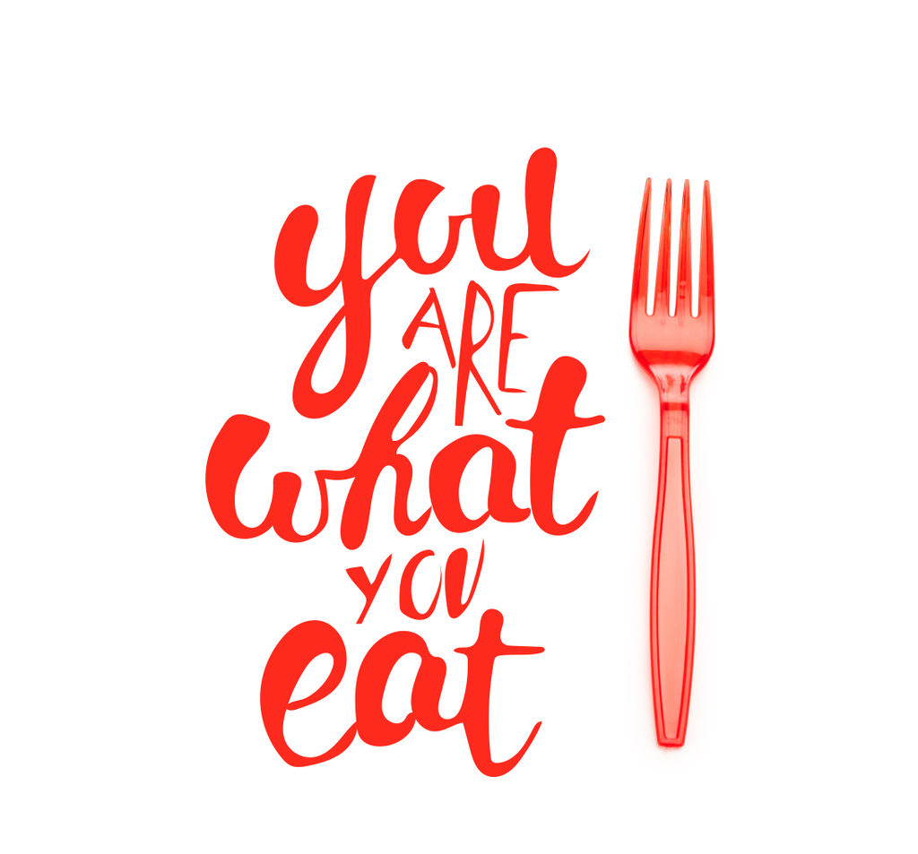 red plastic bright fork near you are what you eat lettering isolated on white  - Photo, Image