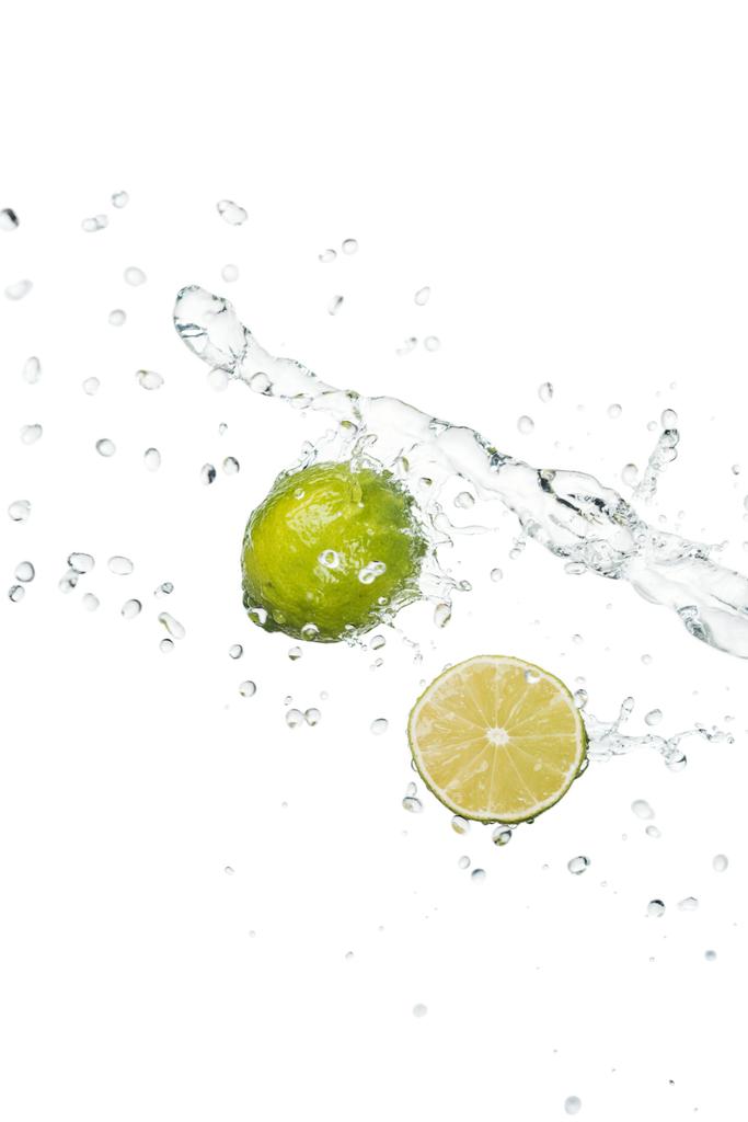 limão inteiro fresco verde e metade com respingo de água clara e gotas isoladas em branco
 - Foto, Imagem