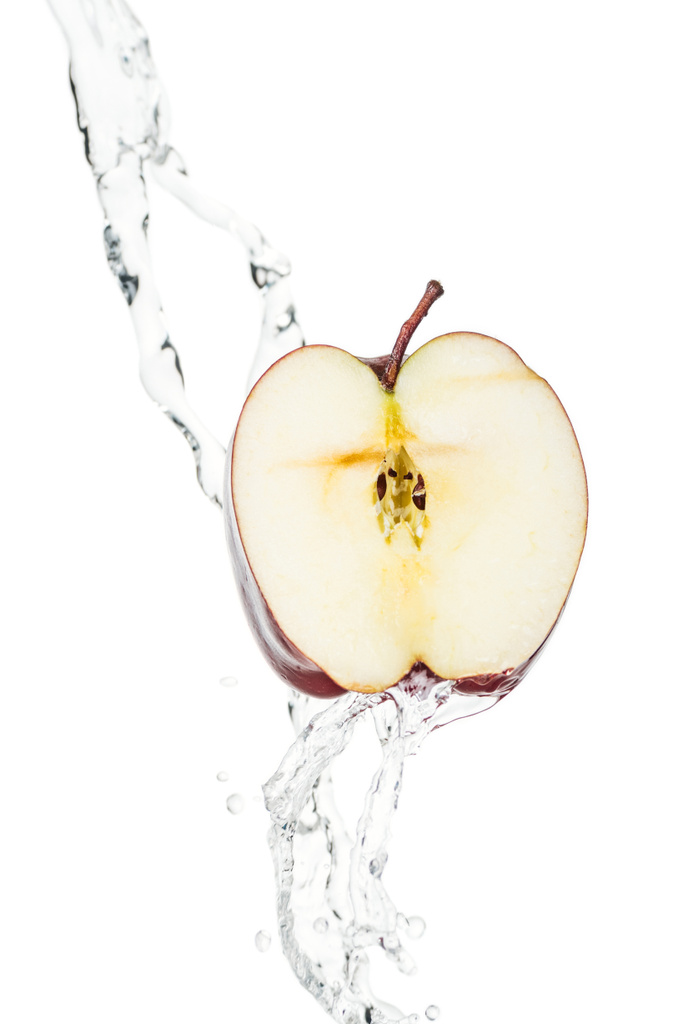 熟した赤いリンゴの半分と白に隔離された滴と透明な水の流れ - 写真・画像