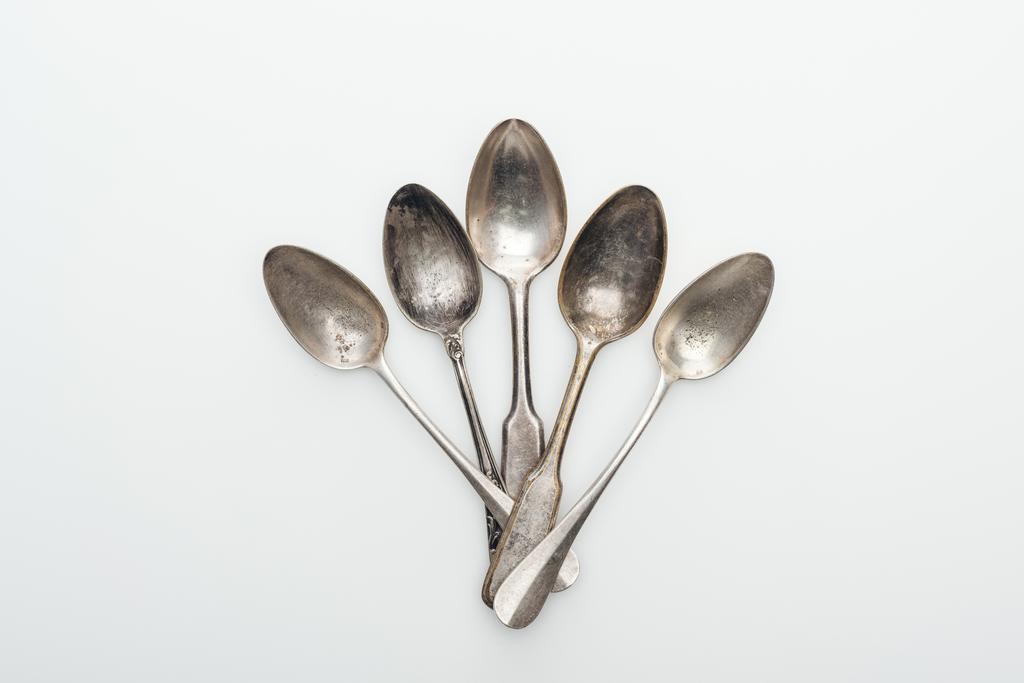 vista dall'alto di lucido invecchiato cucchiai vuoti d'argento su sfondo bianco
 - Foto, immagini