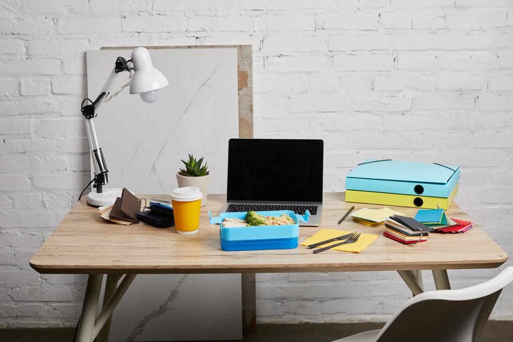 Обеденная коробка с вкусной едой на рабочем месте с ноутбуком и бумагами на деревянном столе на белом фоне, иллюстративная редакция
 - Фото, изображение