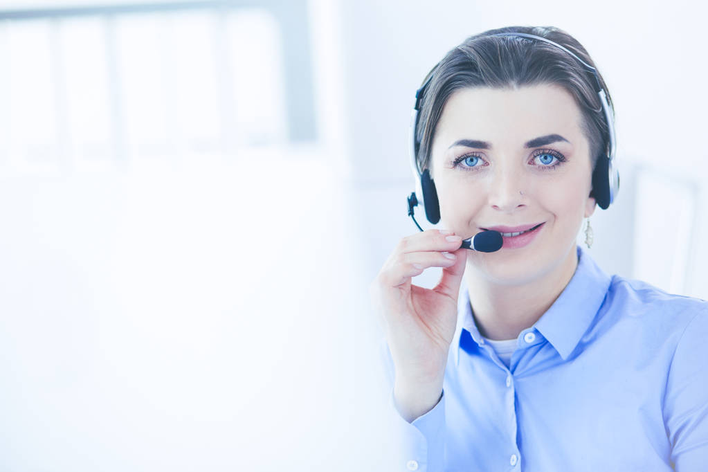 Poważne ładna młoda kobieta pracuje jako operator telefoniczny wsparcia z zestawu słuchawkowego w biurze - Zdjęcie, obraz