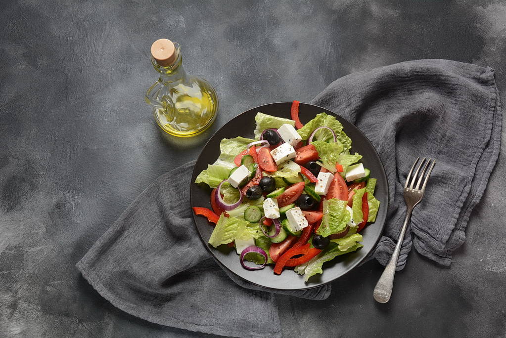 Salada grega com pepino fresco, tomate cereja, pimenta doce, alface, cebola vermelha, azeitonas e azeite e queijo feta. Conceito de alimentação saudável
  - Foto, Imagem