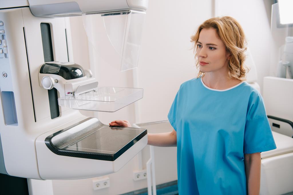 gyönyörű felnőtt nő áll közel röntgen gép a kórházban  - Fotó, kép