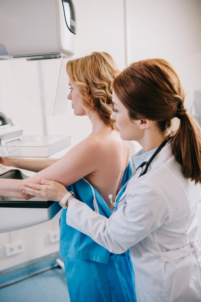 tarkkaavainen radiologi valmistelee naista mammografiatestiin röntgenlaitteella
 - Valokuva, kuva