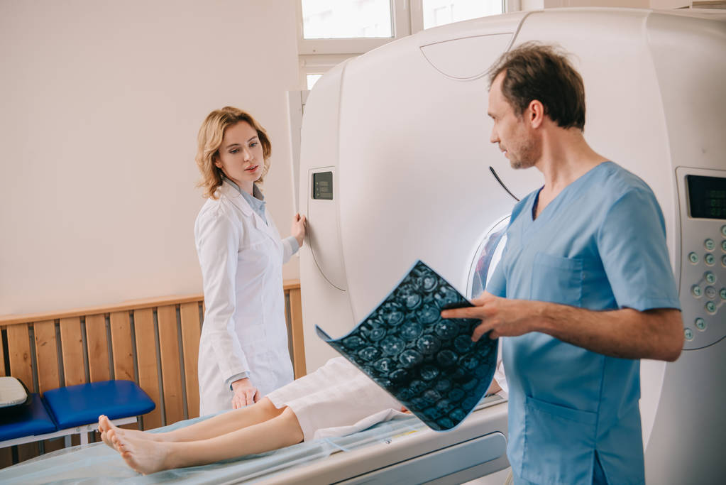Lekarz prowadzący diagnostykę tomografii, podczas gdy radiolog działający skaner CT podczas diagnostyki pacjentów - Zdjęcie, obraz