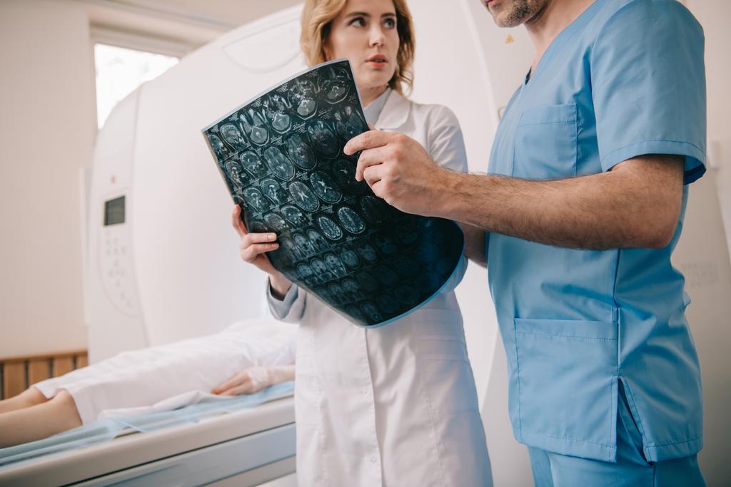 vista ritagliata del medico che esamina la diagnosi di tomografia insieme al radiologo
 - Foto, immagini
