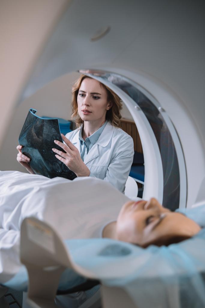 selectieve focus van doordachte radioloog die x-ray diagnose houdt tijdens diagnostiek van patiënten  - Foto, afbeelding