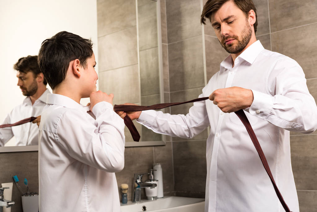 father and son dressing in formal wear in bathroom - Photo, Image