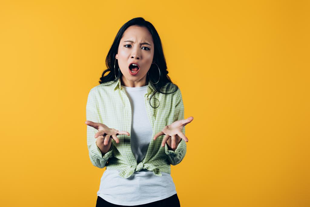 агресивна азіатська жінка кричить ізольовано на жовтому
 - Фото, зображення