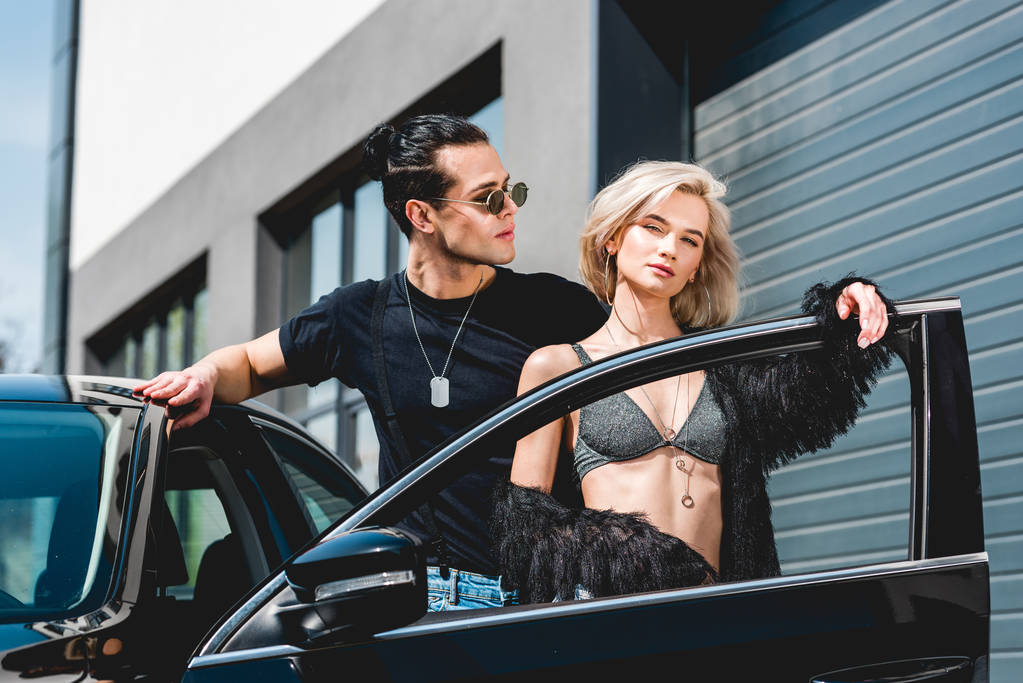стильный красивый мужчина и красивая сексуальная девушка, позирующая возле машины
 - Фото, изображение