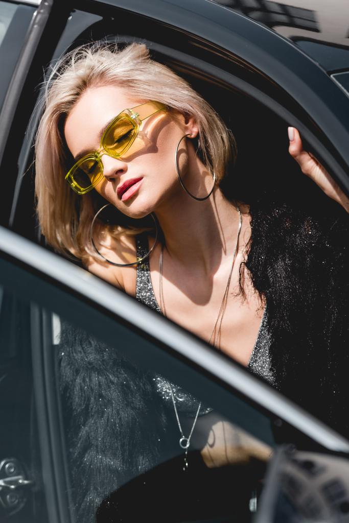 красива модна сексуальна молода жінка в окулярах позує в машині з закритими очима
 - Фото, зображення