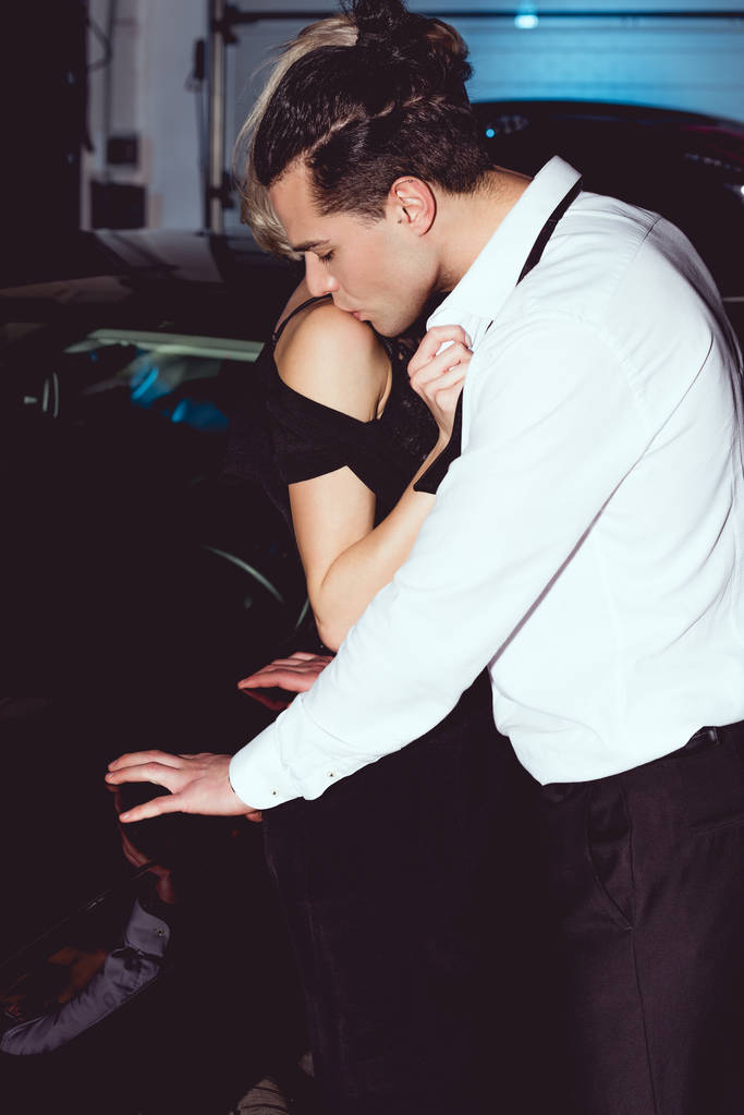 sensual elegante pareja en formal desgaste besos cerca de coche
 - Foto, imagen