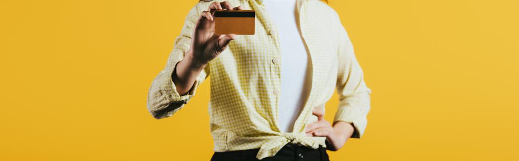 обрізаний вид жінки, що тримає кредитну картку, ізольовано на жовтому
 - Фото, зображення