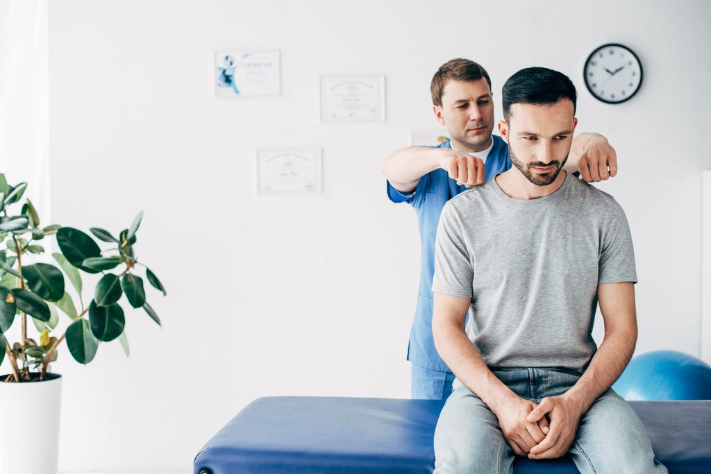 хіропрактичний масаж спини доброзичливого чоловіка на масажному столі в лікарні
 - Фото, зображення