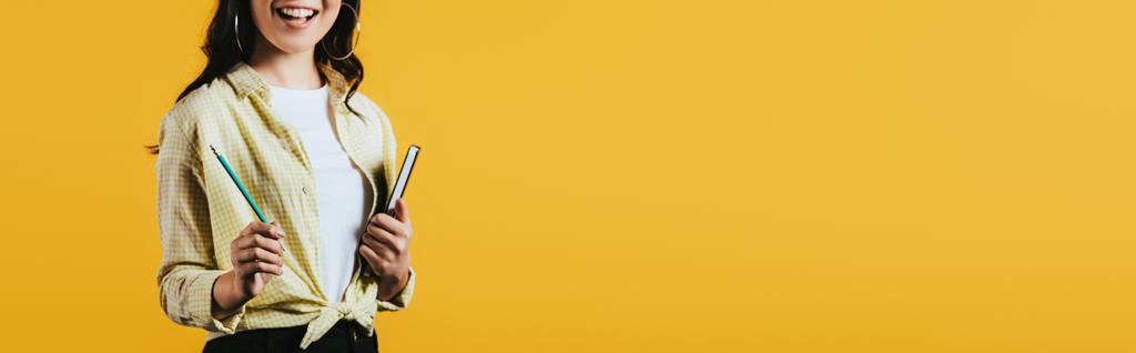 vista ritagliata di ragazza con notebook e penna, isolato su giallo
  - Foto, immagini