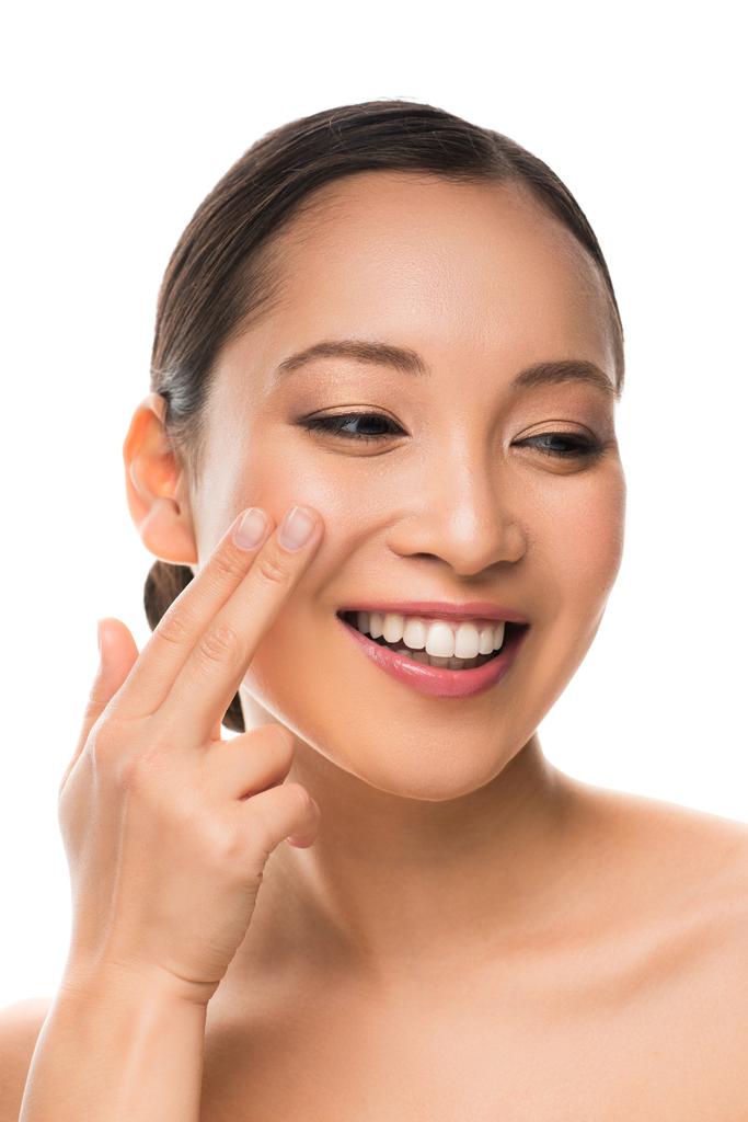 attraente sorridente asiatico ragazza applicando crema isolato su bianco
 - Foto, immagini