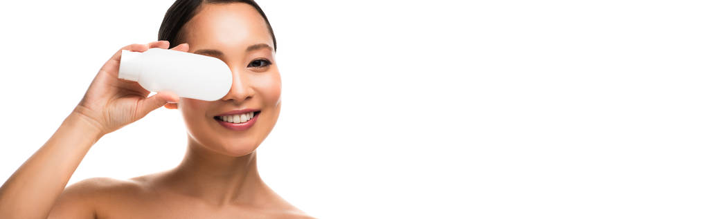 sourire asiatique fille avec bouteille de lotion, isolé sur blanc
 - Photo, image