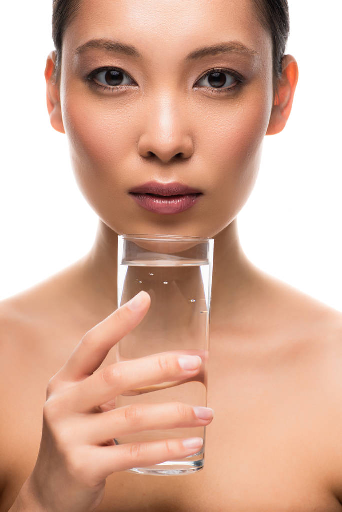 красива азіатська жінка тримає склянку води, ізольована на білому
 - Фото, зображення