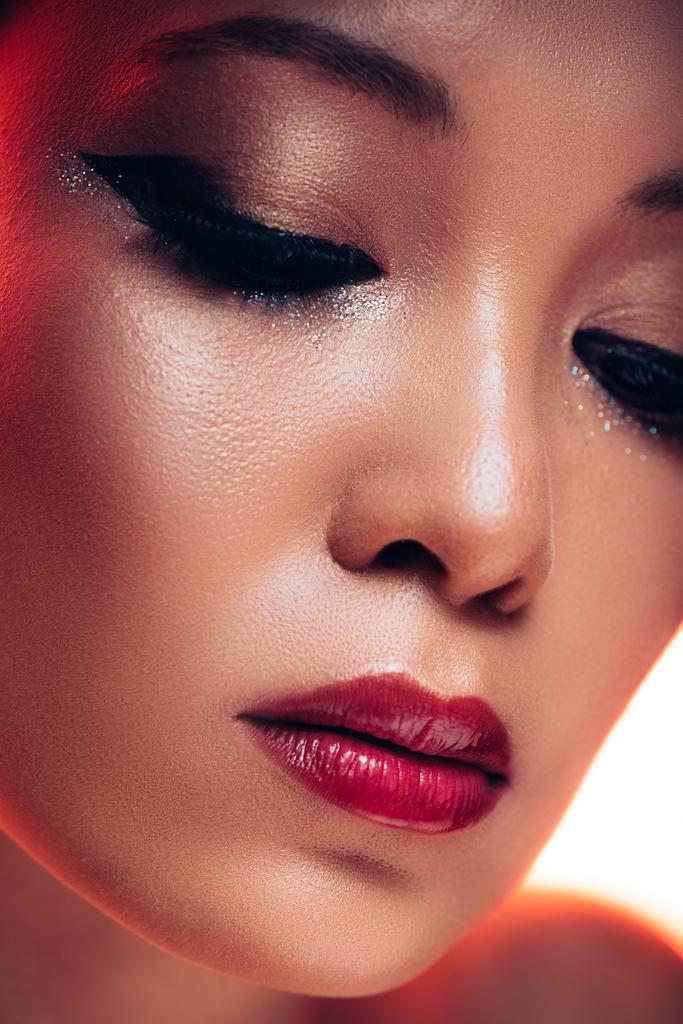 ελκυστική Ασίας νεαρή γυναίκα με μακιγιάζ στο κόκκινο φως  - Φωτογραφία, εικόνα