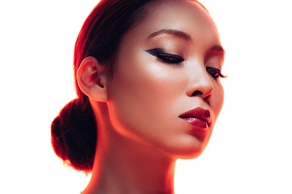 赤い光の化粧をしたブルネットアジアの女性, 白に隔離 - 写真・画像