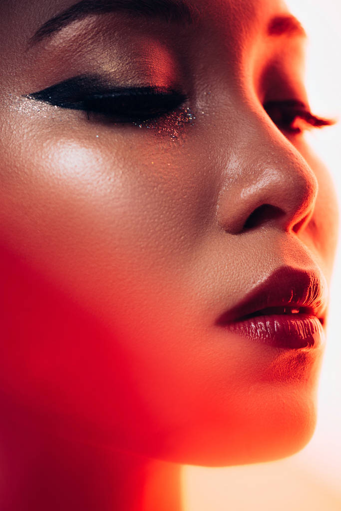 привлекательная азиатская женщина в красном свете, тонированное изображение
 - Фото, изображение