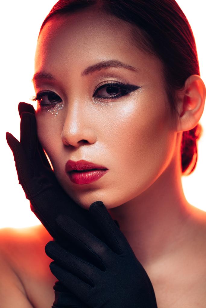 赤い光の化粧で黒い手袋をしたアジアの女性, 白で隔離 - 写真・画像