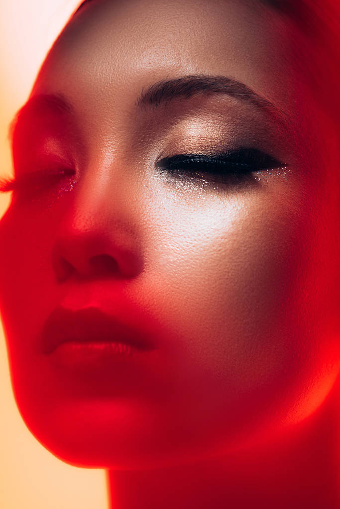 close up de atraente menina asiática com maquiagem em luz vermelha
  - Foto, Imagem