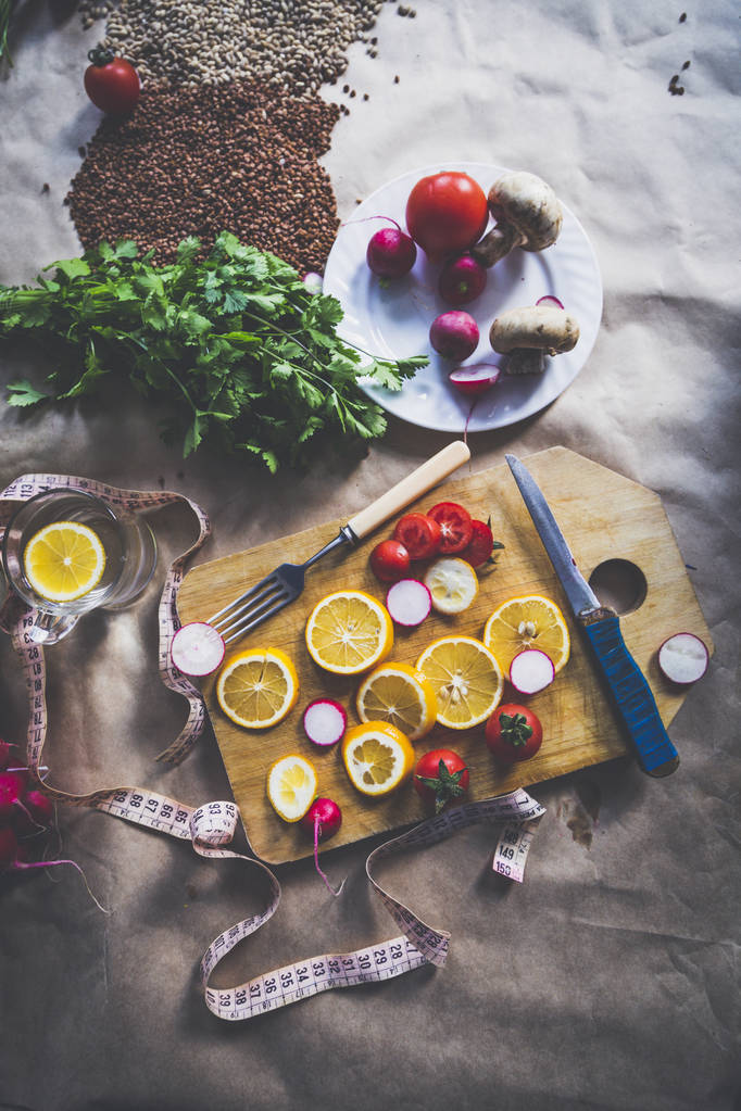 Egészséges vegán élelmiszer háttér vágódeszkával és citromszeletekkel - Fotó, kép