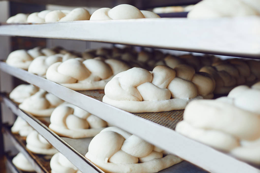 frisches Brot auf Blechen vor dem Backen im Backofen beim Bäcker - Foto, Bild