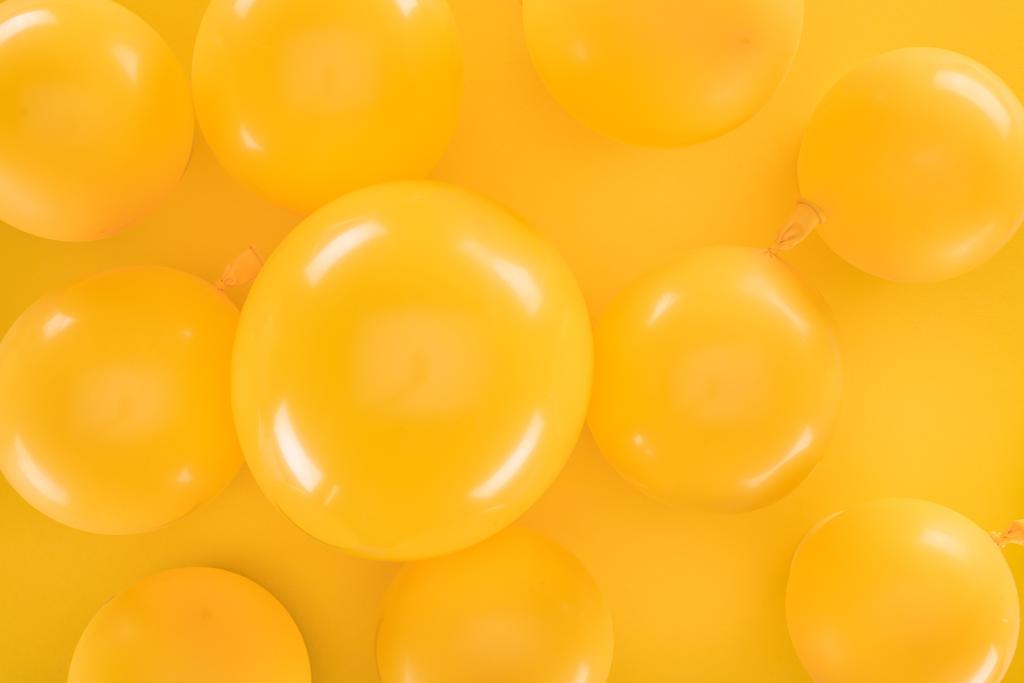 Top view keltainen ilmapalloja keltaisella pohjalla
 - Valokuva, kuva