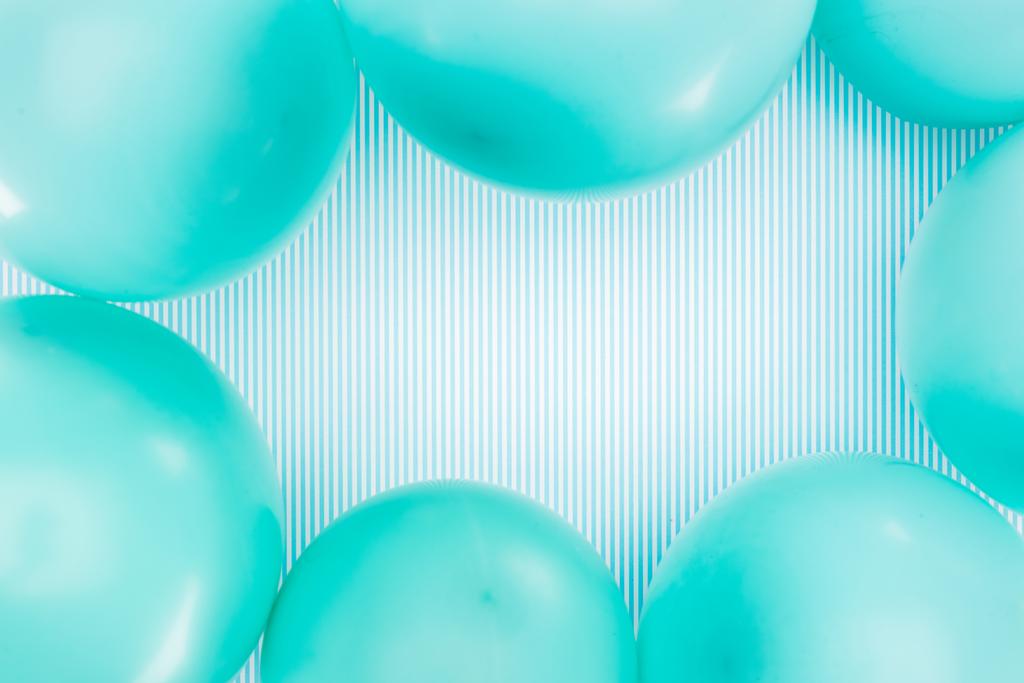 Вид сверху на рамку синих воздушных шаров на полосатом фоне
 - Фото, изображение