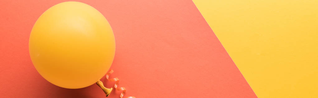 Panorâmica tiro de balão amarelo sobre fundo minimalista coral
  - Foto, Imagem